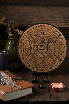 Mystic Wheel of the Year with runes and ritual items on a wooden table. Spiritual and pagan concept.