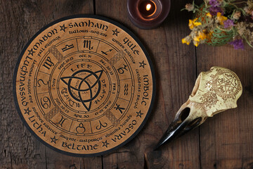 Overhead view of a wooden Wheel of the Year engraved with the eight pagan festivals. Spiritual and...