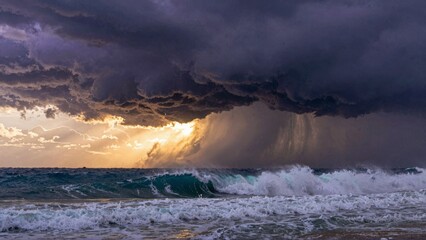 Ocean waves crashing under thunderstorm clouds with sunlight