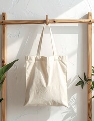 Minimalist Beige Canvas Tote Bag Hanging on Wooden Frame.