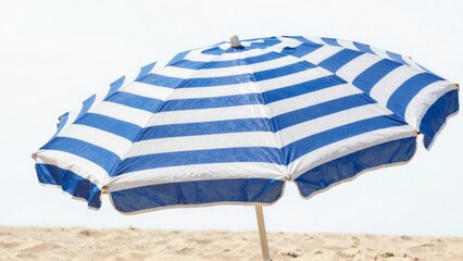Blue and white striped beach umbrella on sandy shore