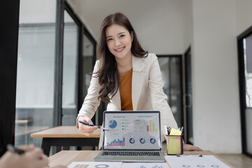Asian businesswoman using digital laptop with business analyzing financial charts in the modern office.