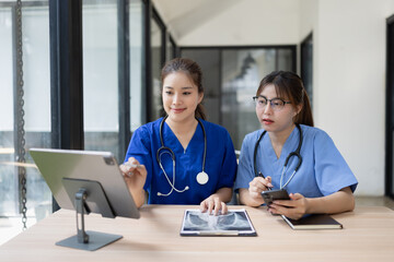 Two asian female doctor using computer with clipboard in modern clinic, Doctor woman and medical coat working in hospital.