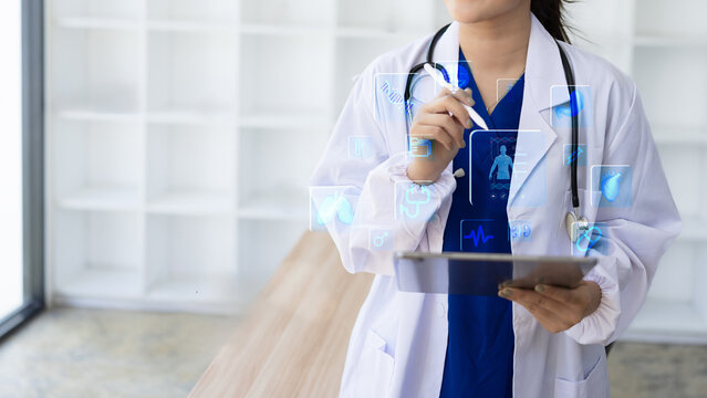 Female doctor holding a stethoscope, Healthcare And Medicine concept. Doctor using digital tablet with modern virtual screen interface. - Powered by Adobe