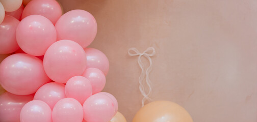 Soft pastel balloon decoration with pink and peach balloons on beige background. Delicate festive scene with copy space, suitable for baby shower, birthday or gentle celebration design.