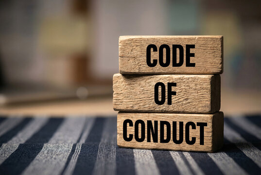 Code of conduct wooden blocks stacked on rustic table, business ethics compliance standards concept.
