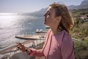 Woman relaxation seaside Beautiful woman enjoying the sun and fresh sea air on a sunny balcony