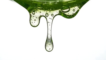 Green viscous liquid with air bubbles dripping from an edge on a white background slime