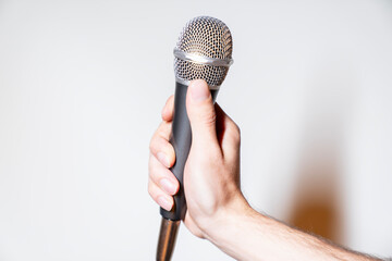 hand holding microphone against a white background