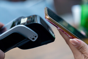 Close-up of a customer making a contactless payment with a smartphone.