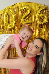 mulher celebra com bebe 2026 dourado 