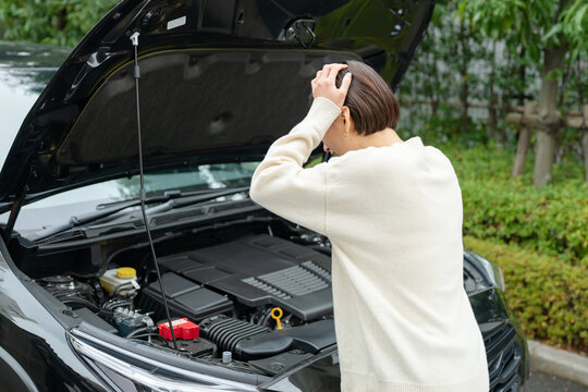 車の故障で悩む女性