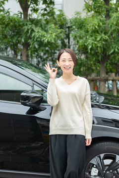 車の前に立つ女性