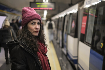 Attractive Forty Year Old Woman Wearing a Winter Hat Traveling Standing on the City Metro