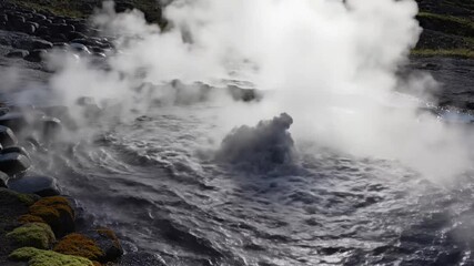 Dramatic slow motion of a geyser erupting with boiling water and steam on a sunny day in Iceland
