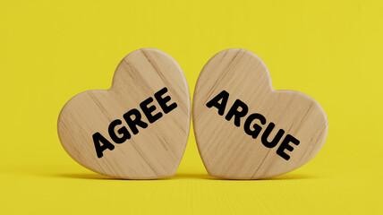 Wooden hearts displaying the words agree and argue against a yellow background