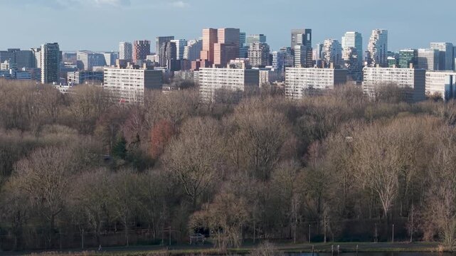 Aerial reveal shot of the Skyline of Amsterdam Zuidas financial district seen from river Amstel