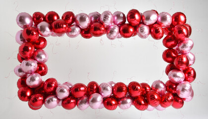 Obraz premium Red and pink metallic balloons arranged in a rectangular frame shape.