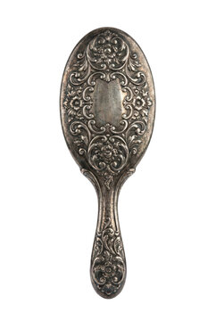 Antique silver hairbrush with ornate floral pattern. Victorian vanity accessory.