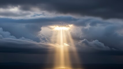 Sunlight breaking through dark storm clouds over the ocean.