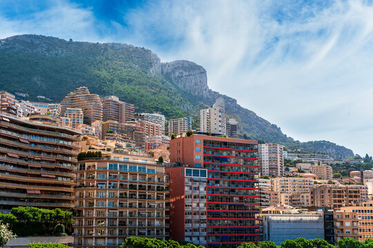 cityscape sunset view of a Monte Carlo city in Monako with high buildings, tall skyscrapers and industrial landscape with evening mountains on background