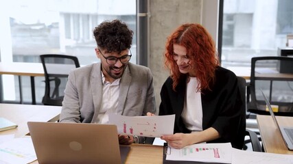 Business colleagues collaborating on a startup project, analyzing data and discussing documents while working together in a modern office - Powered by Adobe