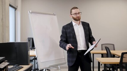 Bearded man in a suit presenting complex data and charts on a flip chart, teaching business concepts to professionals - Powered by Adobe