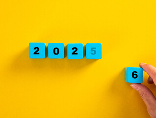 Hand changing year from 2025 to 2026