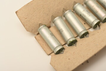 Old capacitors in paper packaging. Aluminum capacitors for electronic devices.