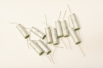 Old capacitors in paper packaging. Aluminum capacitors on a white background. Electronic components.