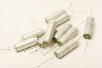 Old capacitors in paper packaging. Aluminum capacitors on a white background. Electronic components.