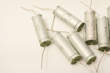 Old capacitors in paper packaging. Aluminum capacitors on a white background. Electronic components.
