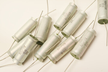 Old capacitors in paper packaging. Aluminum capacitors on a white background. Electronic components.