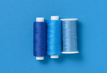Blue thread spools background with copy space for text close-up flat lay top view