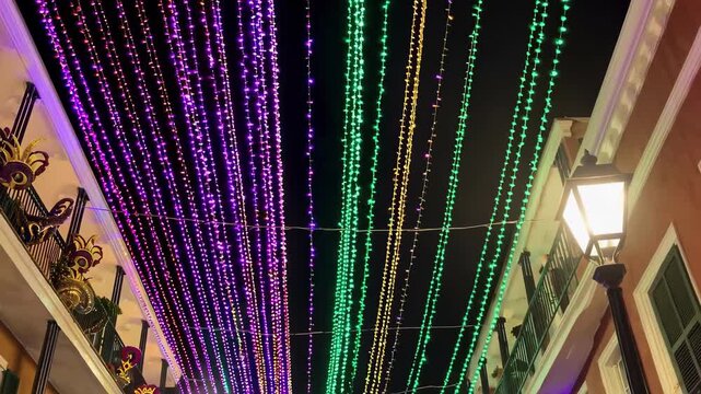 Colorful mardi gras celebration with vibrant purple, green, and yellow lights brightening the night in a festive street scene. concept of festive celebration, street decor, nightlife