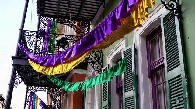 Colorful mardi gras street with vibrant banners and historic architecture celebrating festive spirit in new orleans. concept of mardi gras decor, urban celebration, cultural festival