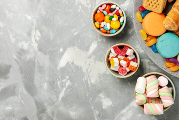 Colorful Assortment of Sweet Candies Marshmallows and Pastries on Grey Background