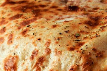 Close Up of Golden Brown Baked Flatbread Crust with Dried Herbs Texture