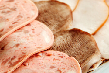 Close Up View of Assorted Gourmet Sliced Deli Meats on White Background