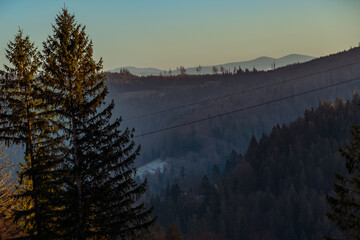 Obraz premium Scenic mountain landscape at sunset, warm sky colors, natural light, and a peaceful atmosphere. A perfect scene capturing the beauty of mountains during golden hour.