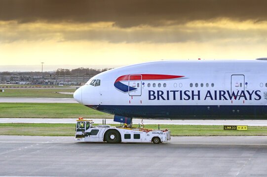 London, England, UK - 11 January 2024: British Aiways Boeing 777 being towed to the mainteance hangar by an aircraft tug
