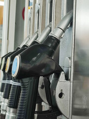 Close-up of fuel dispensing nozzles at a gas station, mobile phone photography