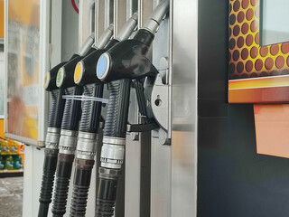 Close-up of fuel dispensing nozzles at a gas station, mobile phone photography