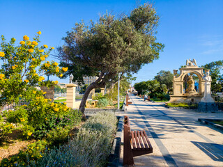 Valletta park promenade with historic fountain and bust in the old town