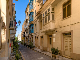 Valletta old town narrow street with traditional Maltese balconies and limestone facades