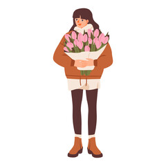 Woman in a cozy winter outfit holding a large bouquet of pink flowers, conveying warmth, calmness, and seasonal charm.