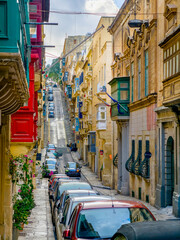 Valletta old town narrow street with traditional Maltese balconies and limestone facades
