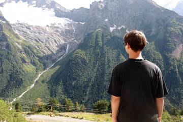 Man observing majestic mountain landscape with snow-capped peaks
