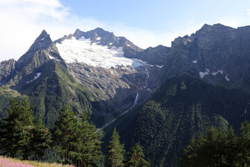 Picturesque view of Caucasus Mountains with glacier and waterfall