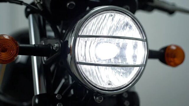 Close-up of a motorcycle's illuminated headlight with turn signals